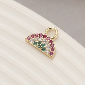 Macro shot of watermelon charm with micro-pave red and green zircon in gold setting