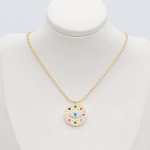 Makroansicht der goldenen Perlenkette mit Evil Eye Anhänger und bunten kleinen Steinen