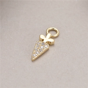 Detailed macro view of golden carrot-shaped pendant with cubic zirconia inlay for jewelry