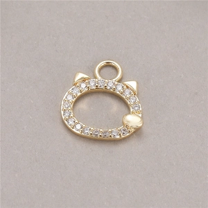 Macro view of gold-plated cat head pendant charm with sparkling cubic zirconia stones