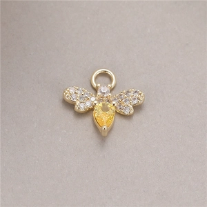 Detailed view of golden bee pendant with micro-paved white and yellow zircon stones