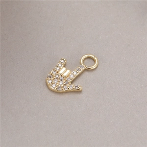 Macro shot of gold hand gesture pendant with micro-paved sparkling cubic zirconia
