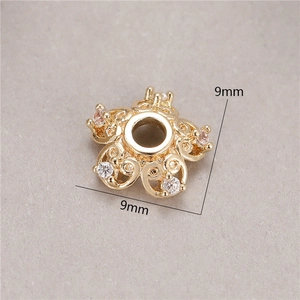 Macro shot of 9mm 14K gold plated flower bead spacer with pink zircon and hollow patterns
