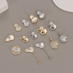 Macro shot of gold and silver gourd charms with white mother of pearl and zircon stones