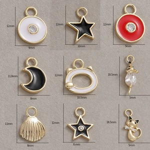 Macro detail of various 14K gold plated charms with cubic zirconia and enamel icons