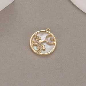 Macro shot of circular mother of pearl pendant featuring a diamond-encrusted unicorn and moon