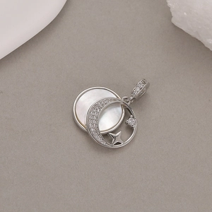Macro detail of crescent moon and star pendant with white mother of pearl inlay