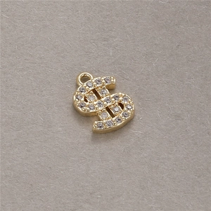 Detail eines vergoldeten Dollarzeichen-Anhängers mit Zirkonia für DIY-Schmuck