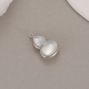 Macro view of a polished silver hulu pendant with white mother of pearl inlay