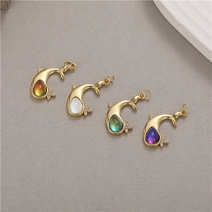 Detailed view of gold whale tail pendants with colorful zircon inlays and star accents