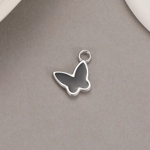 Detailed view of silver bow-shaped butterfly pendant with black enamel inlay for DIY jewelry