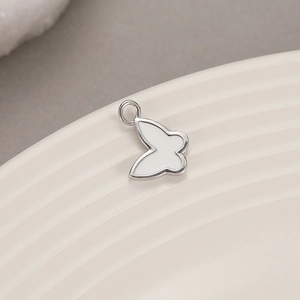 Detailed macro view of white enamel butterfly charm pendant for DIY jewelry making