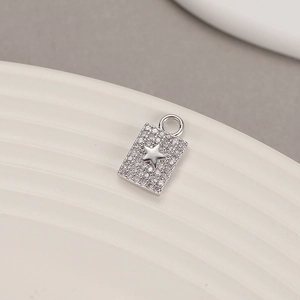 Macro shot of a silver rectangle pendant with micro-set zircon stones and a star motif