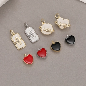 Macro shot of 14K gold plated charms with zircon elephant, bow, and luck heart designs