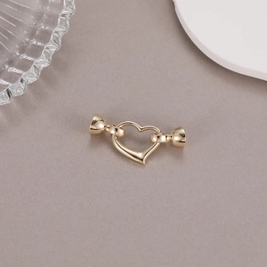 Vue macro détaillée d'un fermoir en forme de cœur doré poli pour la création de bijoux DIY