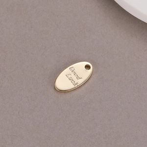 Ciondolo ovale placcato oro lucido con dettaglio inciso della scritta Good Luck