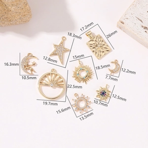 Detailed macro of 14K gold-plated celestial charms including sun, moon and star shapes