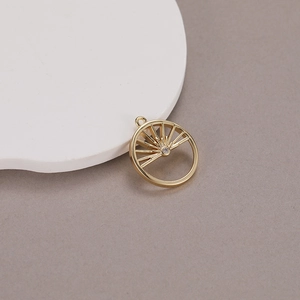 Detailed macro view of 14K gold plated sun pendant with hollow design and central zircon