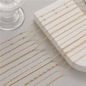 Collection of elegant gold plated copper chain necklaces in various link styles on white stands