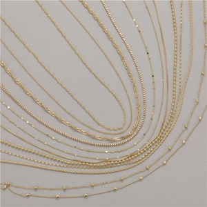 Collection of golden brass necklace chains in various styles like water wave and curb link
