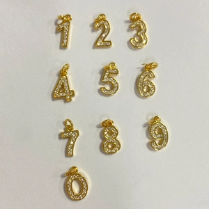 Macro detail of gold-plated 0-9 number pendants with micro-pave cubic zirconia