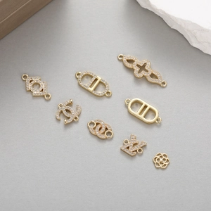Detailed view of 14K gold plated charms with zircon inlay and luxury fashion motifs