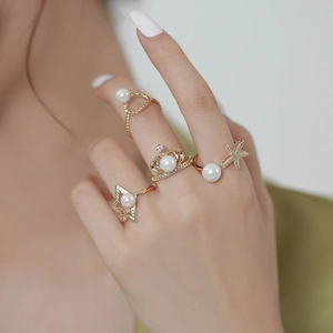 Détails de quatre bagues plaquées or avec perles et zircon sur les doigts du mannequin