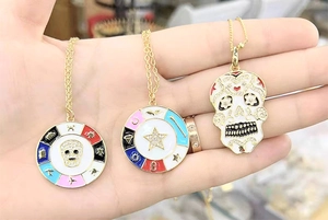 Macro shot of colorful enamel skull and star pendants with sparkling zircon inlays