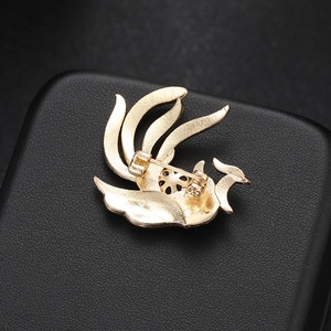 Detailed back view of gold phoenix brooch showing secure safety pin and polished finish