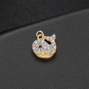 Macro view of 14K gold whale pendant featuring blue and white gradient micro-pave zircons