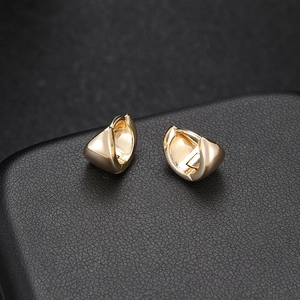 Minimalist vintage style 14k gold plated huggie hoop earrings on black leather base