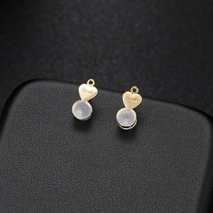 Gros plan de fermoirs de boucles d'oreilles en cœur doré gravés love avec silicone