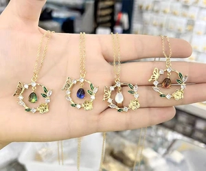 Detail of 14K gold plated flower and butterfly pendants with colorful teardrop gemstones