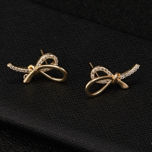 Exquisite mit 14K Gold überzogene Schleifen-Ohrringe mit Zirkonia-Besatz auf Schwarz
