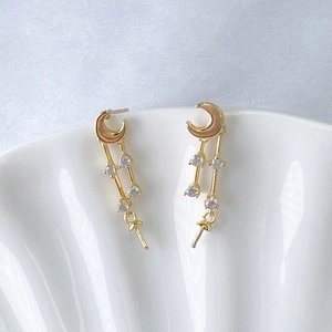 Detail of gold moon-shaped earring with pink enamel and cubic zirconia stones