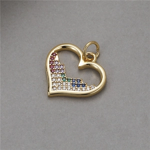 Dettaglio macro del ciondolo a cuore dorato con micro-intarsio di zirconi colorati su grigio