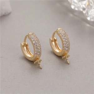 Detalle macro de aretes en forma de U dorados con pavé de circón y pernos para perlas