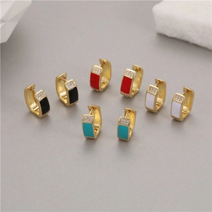 Primer plano de pendientes garra de oso en esmalte negro rojo blanco y azul con circonitas