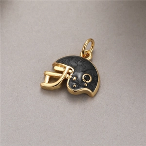 Macro detail of gold plated football helmet pendant with black enamel and zircon inlay