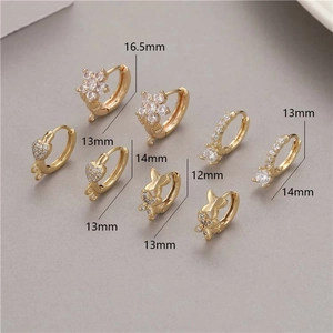 Detailed view of assorted gold huggie hoops with zircon hearts, stars and butterflies