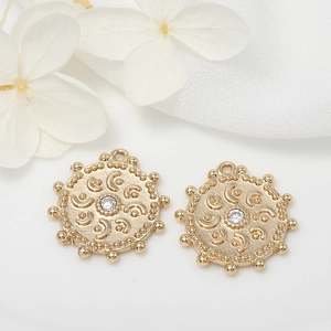 Macro detail of gold-plated round evil eye charms with zircon inlays and beaded edges