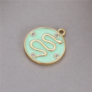 Gros plan d'un pendentif en émail vert menthe avec motif serpent doré et cristaux