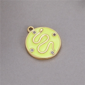 Détail du pendentif rond en émail vert avec motif serpent doré et accents en zircon
