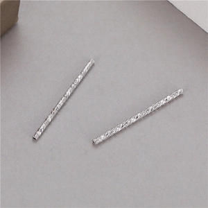Vue macro de perles cylindriques argentées texturées pour la création de bijoux