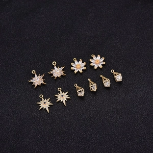 Detailed macro view of 14K gold-plated star and floral charms with cubic zirconia stones