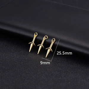 Macro detail of three 14K gold plated kunai charms showing dimensions 25.5mm by 9mm
