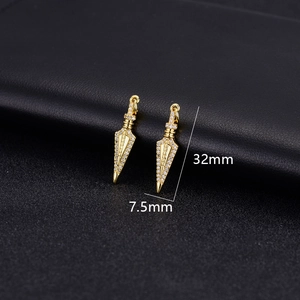 Macro detail of 14K gold plated dagger pendants with white zircon stones, 32mm in length