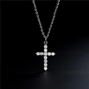 Macro shot of 14K gold cross pendant with 11 sparkling cubic zirconia stones and O-chain