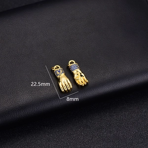 Macro view of 14K gold plated hand pendant with blue zircon wrist detail on black leather