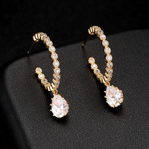 Elegant 14K gold pear drop earrings with cubic zirconia stones on black leather